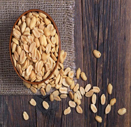 peanuts-in-a-bowl-on-wooden-table-top-down-view